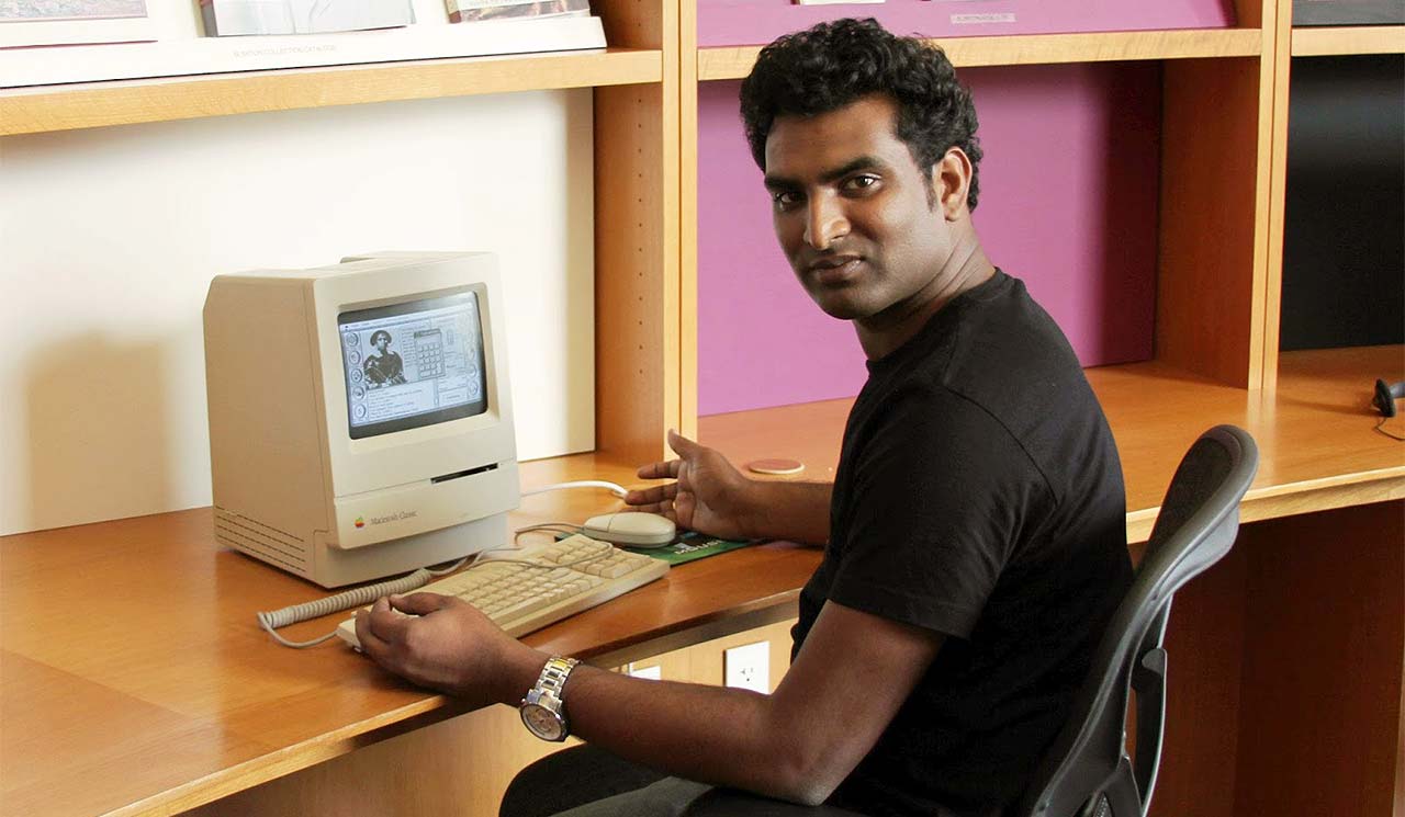 Indian man using a Mac Classic